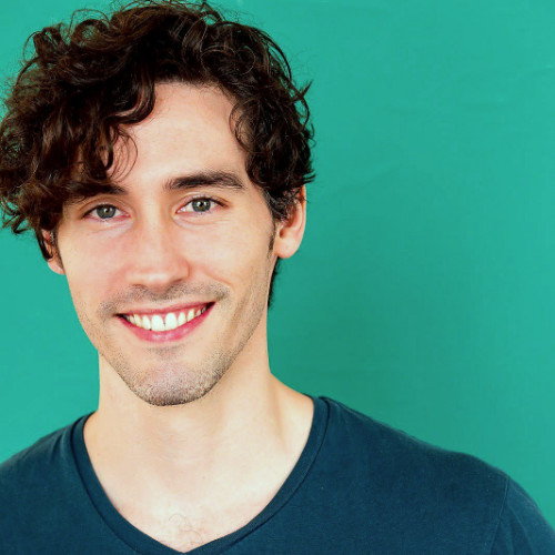 a man in a blue shirt and smiling at the camera