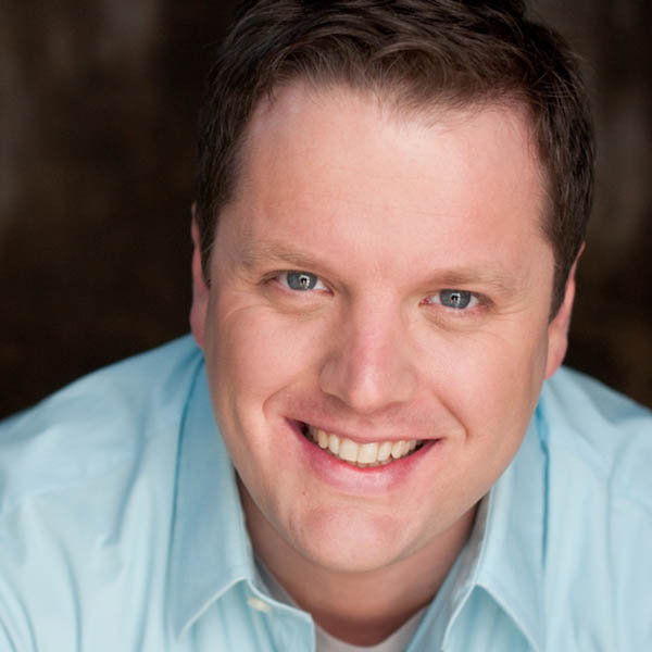 a man wearing a blue shirt and smiling at the camera